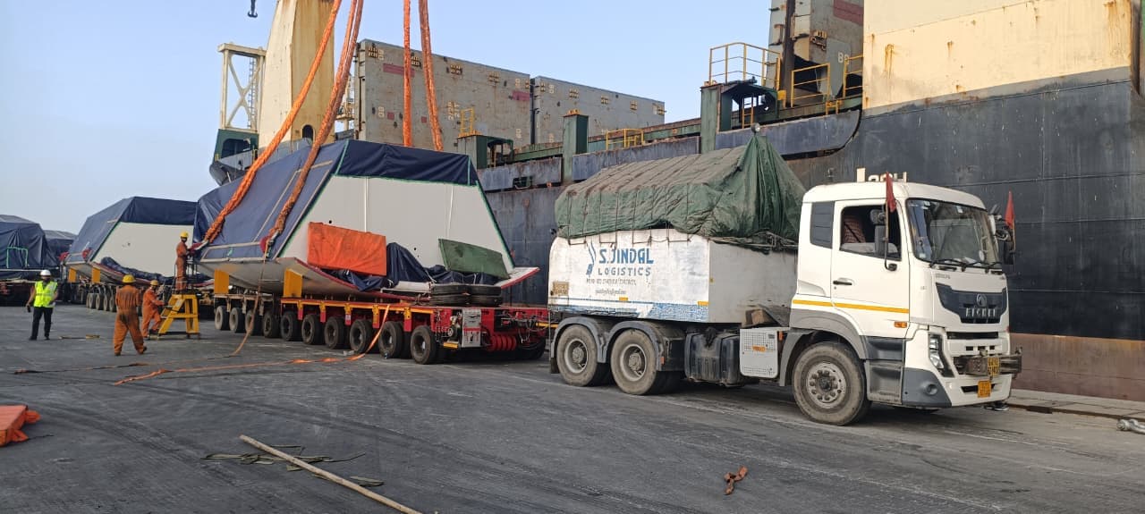 Heavy project cargo at port quay-side — underhook lift onto multi-axle hydraulic trailer.